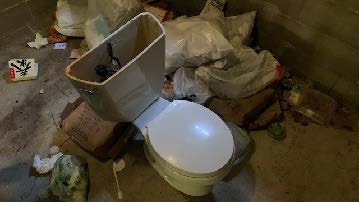dumped old toilet with trash